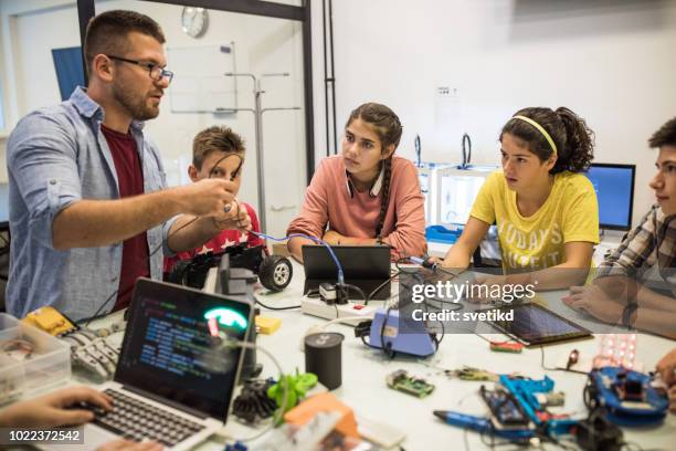 instructor helping students on electronic course - development camp stock pictures, royalty-free photos & images
