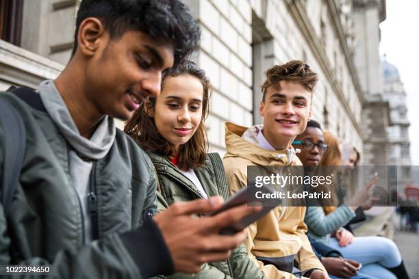jugendliche schüler mit smartphone auf eine schule pause - männlicher teenager stock-fotos und bilder