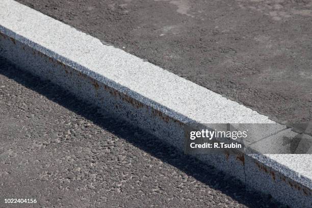 white curb stone border and asphalt road - bordillo fotografías e imágenes de stock
