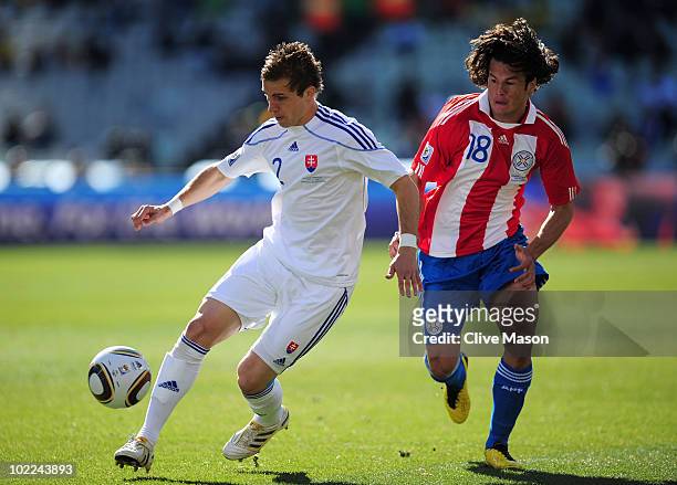 Peter Pekarik of Slovakia runs with the ball as Nelson Valdez of Paraguay closes him down during the 2010 FIFA World Cup South Africa Group F match...