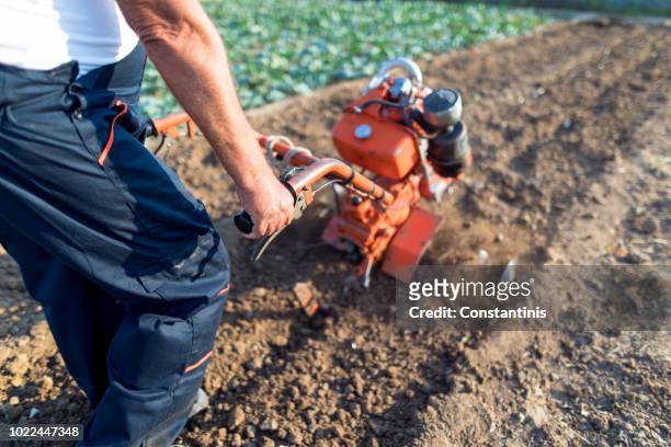 working man with motor cultivator - harrow agricultural equipment stock pictures, royalty-free photos & images