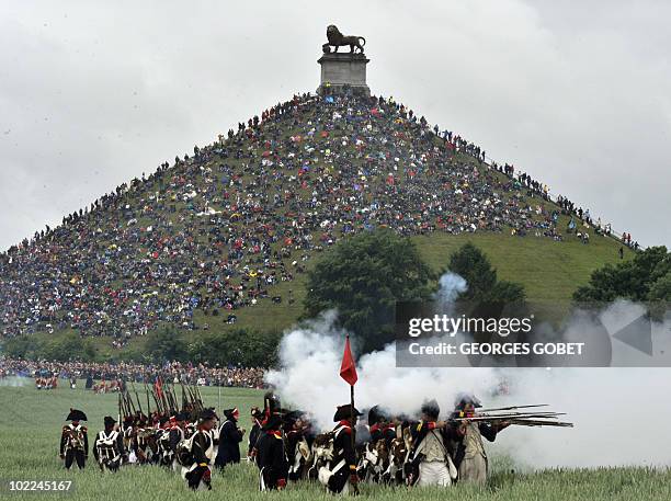 People sit on the Lion's Mound, around the lion monument of the Battle of Waterloo during a re-enactment of the 1815 Battle of Waterloo between the...