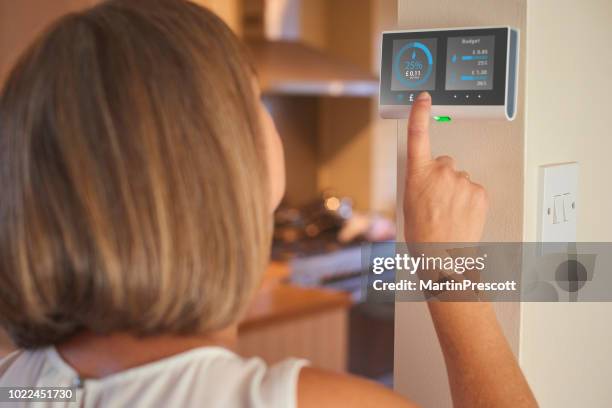 checking home energy consumption - electricity meter stock pictures, royalty-free photos & images