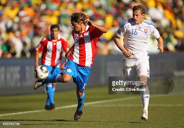 Enrique Vera of Paraguay is pursued by Jan Durica of Slovakia during the 2010 FIFA World Cup South Africa Group F match between Slovakia and Paraguay...