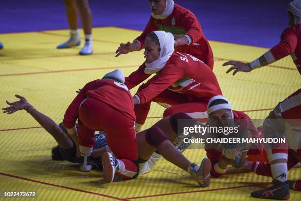 India's Sonali Vishnu Shingate tries to score as Iran's players defend during the women's team kabaddi final match between India and Iran at the 2018...