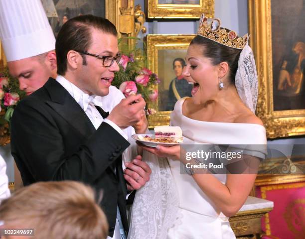 Crown Princess Victoria of Sweden and Prince Daniel, Duke of Vastergotland share a slice of wedding cake during the Wedding Banquet at the Royal...