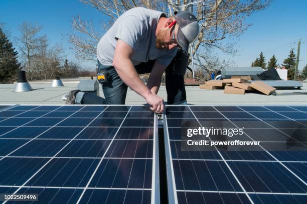 mann, die installation von sonnenkollektoren - miteinander verbunden stock-fotos und bilder