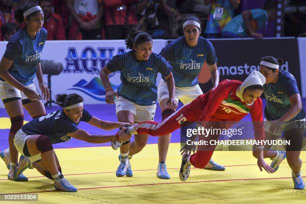 Iran's Sedigheh Jafari tries escort from India's players defend during the women's team kabaddi finals match between India and Iran at the 2018 Asian...