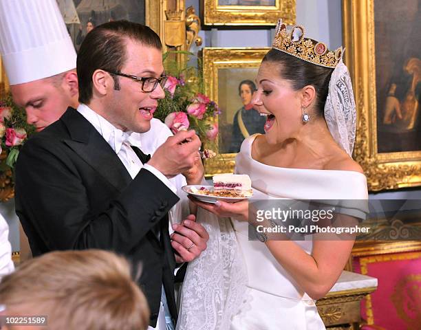 Crown Princess Victoria of Sweden and Prince Daniel, Duke of Vastergotland share a slice of wedding cake during the Wedding Banquet at the Royal...