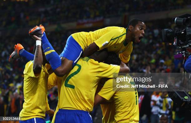 Luis Fabiano of Brazil is mobbed by Robinho and team mates celebrating after scoring the opening goal during the 2010 FIFA World Cup South Africa...