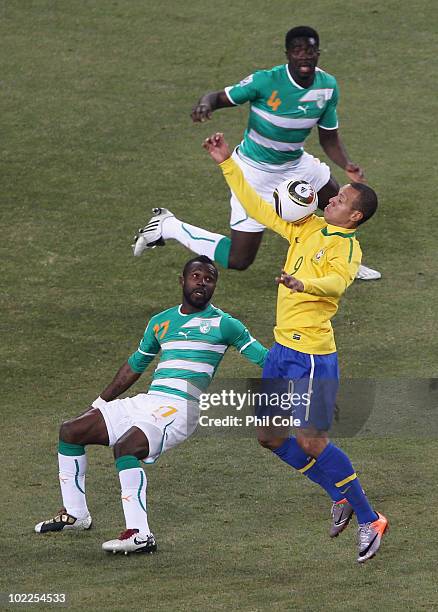 Luis Fabiano of Brazil controls the ball before scoring the second goal as Siaka Tiene and Kolo Toure of the Ivory Coast look on during the 2010 FIFA...