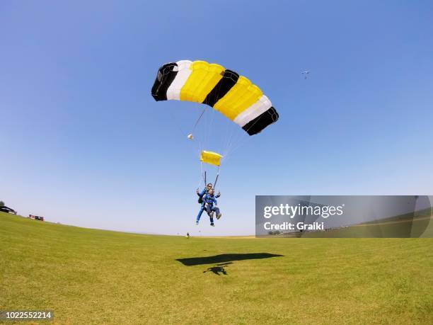 parachute tandem flying in the blue sky - parachutisme en chute libre photos et images de collection