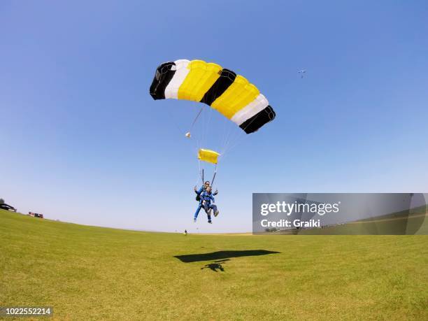 parachute tandem flying in the blue sky - atterrir photos et images de collection