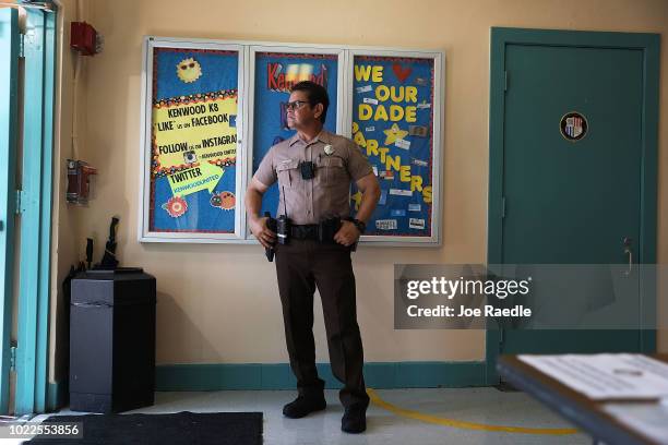 Germany Alech, a Miami-Dade Police officer, stands guard at the front entrance to the Kenwood K-8 Center on August 24, 2018 in Miami, Florida....