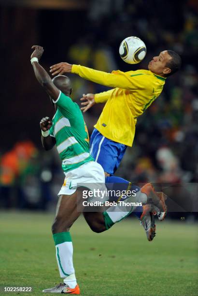 Luis Fabiano of Brazil heads the ball with Didier Zokora of the Ivory Coast during the 2010 FIFA World Cup South Africa Group G match between Brazil...