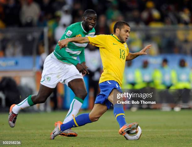 Dani Alves of Brazil is chased by Yaya Toure of the Ivory Coast during the 2010 FIFA World Cup South Africa Group G match between Brazil and Ivory...