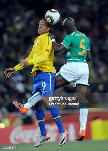 Luis Fabiano of Brazil heads the ball with Didier Zokora of the Ivory Coast during the 2010 FIFA World Cup South Africa Group G match between Brazil...