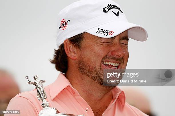 Graeme McDowell of Northern Ireland celebrates with the trophy on the 18th green after winning the 110th U.S. Open at Pebble Beach Golf Links on June...