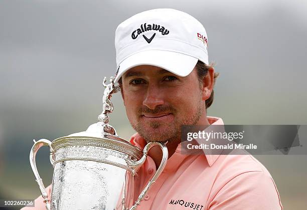 Graeme McDowell of Northern Ireland celebrates with the trophy on the 18th green after winning the 110th U.S. Open at Pebble Beach Golf Links on June...