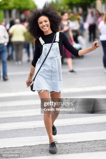 portrait of happy young woman walking on zebra crossing - sac bandoulière photos et images de collection