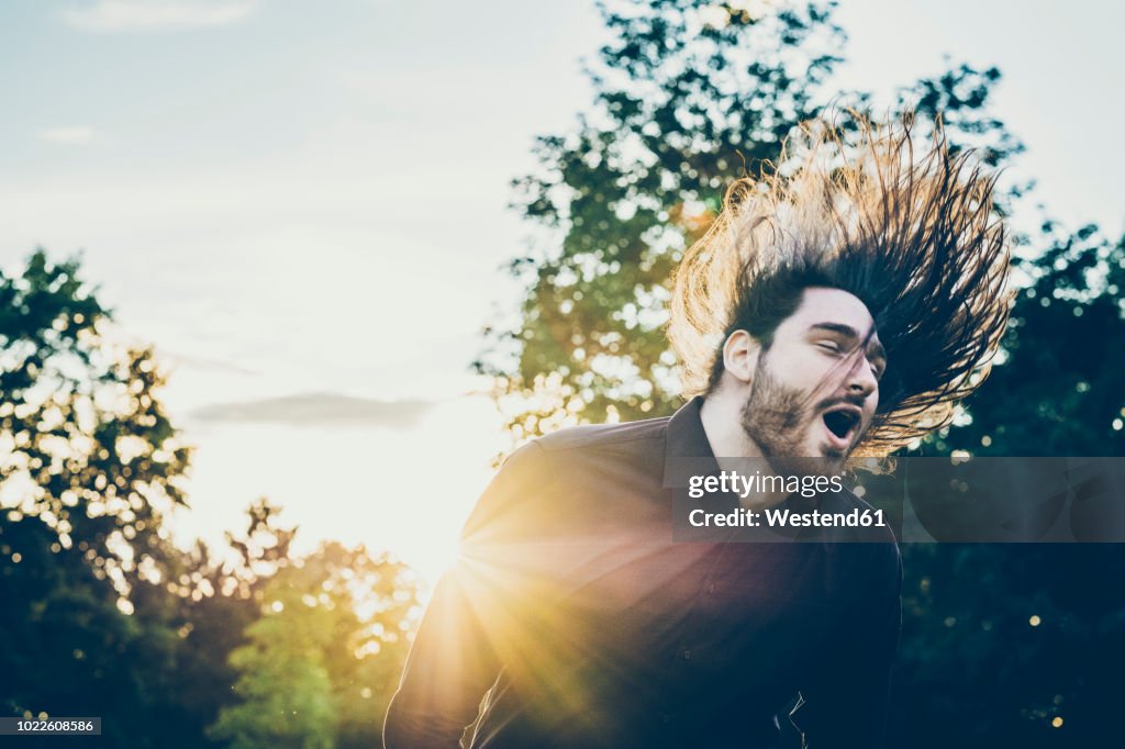 Heavy metal fan headbanging in a park