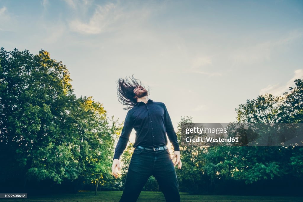 Heavy metal fan headbanging in a park