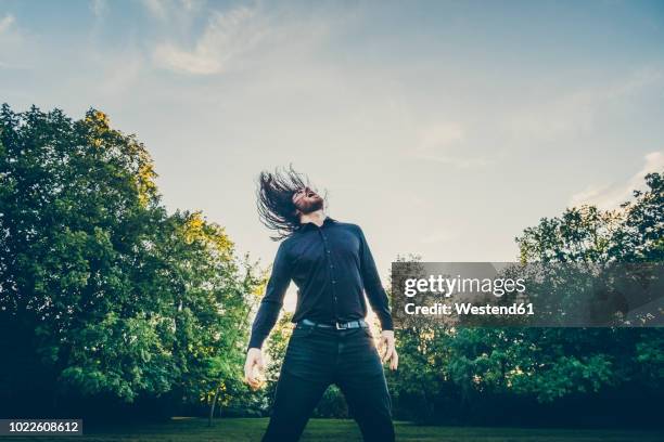 heavy metal fan headbanging in a park - ヘビーメタル ストックフォトと画像