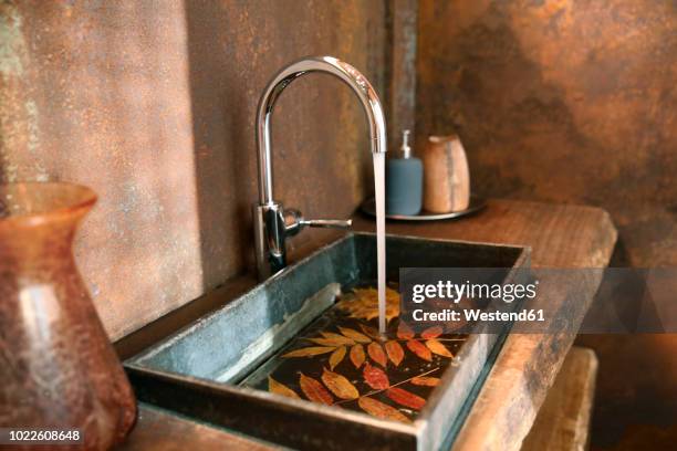 bathroom sink and stainless steel tap in bathroom with corten steel wall cladding - rust deutschland stock-fotos und bilder