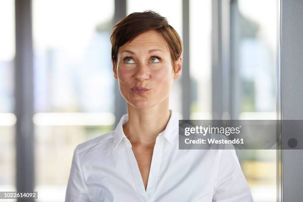 portrait of businesswoman in office pouting looking up - 変な顔　女性 ストックフォトと画像