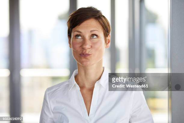 portrait of businesswoman in office pouting looking up - anticipation expression stock pictures, royalty-free photos & images
