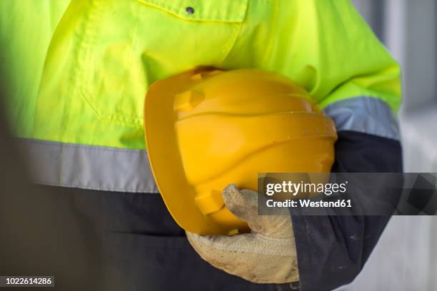 south africa, cape town, builder holding hard hat - vest stock-fotos und bilder