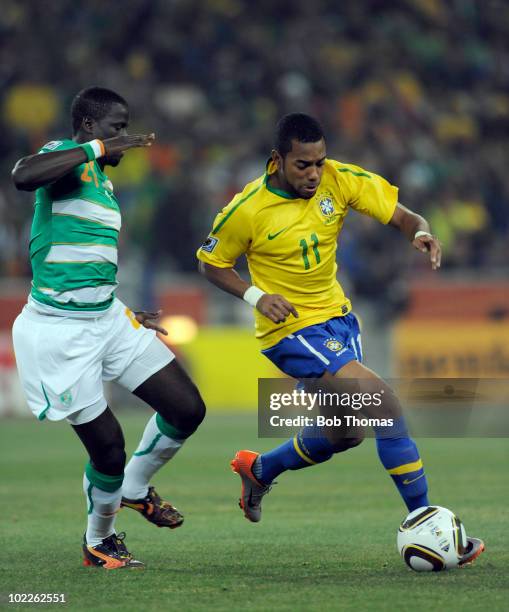 Robinho of Brazil challenged by Emmanuel Eboue of the Ivory Coast during the 2010 FIFA World Cup South Africa Group G match between Brazil and Ivory...