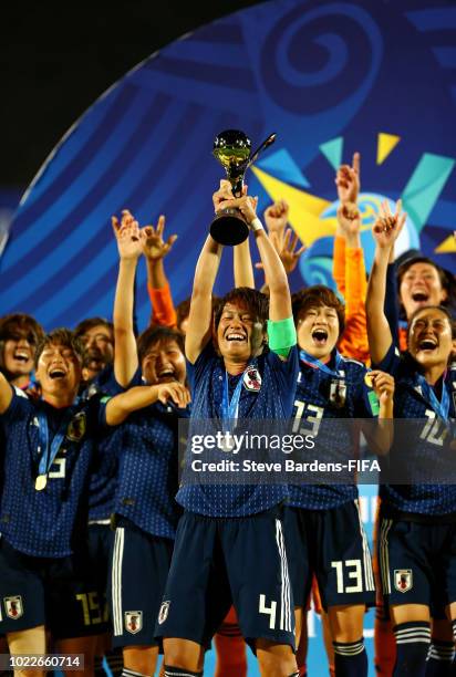 Moeka Minami of Japan lifts the trophy as Japan celebrate victory following the FIFA U-20 Women's World Cup France 2018 Final match between Spain and...