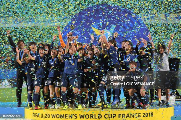 Japan's team players and members of staff celebrate with the trophy after winning the Women's U20 World Cup final football match between Spain and...