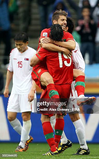 Miguel Veloso of Portugal jumps onto his team mate Tiago after Tiago scored a goal during the 2010 FIFA World Cup South Africa Group G match between...