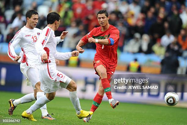 Portugal's striker Cristiano Ronaldo scores the sixth goal past North Korea's defender Ri Kwang-Chon and North Korea's defender Pak Chol-Jin during...
