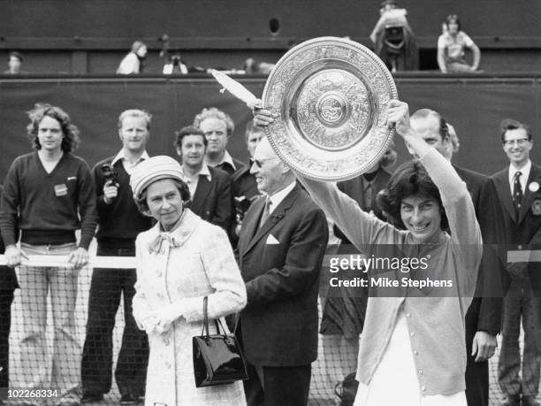 Queen Elizabeth II watches as the Women's Singles Champion, Virginia Wade from Britain, shows her trophy to the crowd on the centre court at...