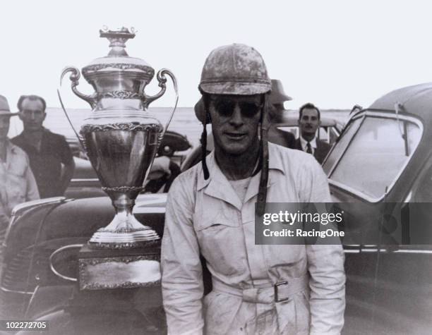 The winner of the first-ever NASCAR sanctioned national points race was Red Byron, shown here with the trophy. He defeated Marshall Teague and his...