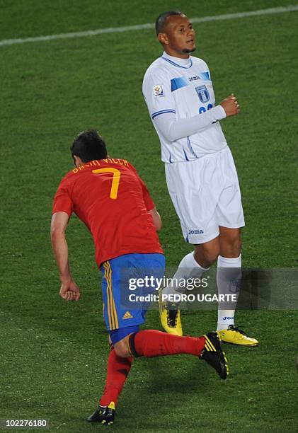 Spain's striker David Villa celebrates past Honduras' defender Sergio Mendoza after scoring the opening goal during the Group H first round 2010...