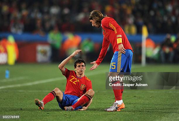 Sergio Ramos of Spain helps up team mate Jesus Navas during the 2010 FIFA World Cup South Africa Group H match between Spain and Honduras at Ellis...
