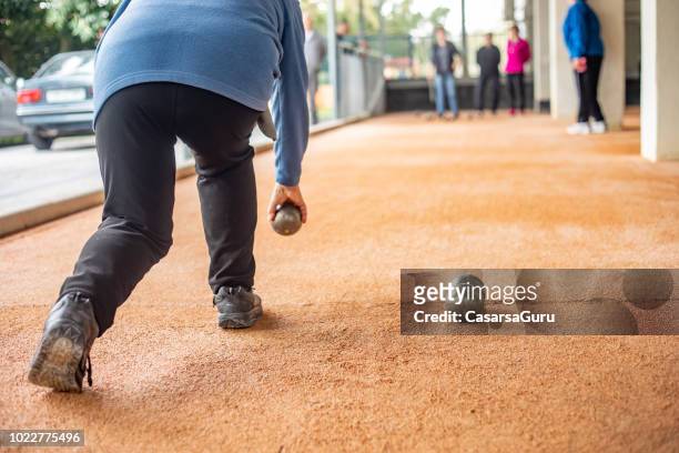 senior woman throwing bocce ball - bocce ball stock pictures, royalty-free photos & images