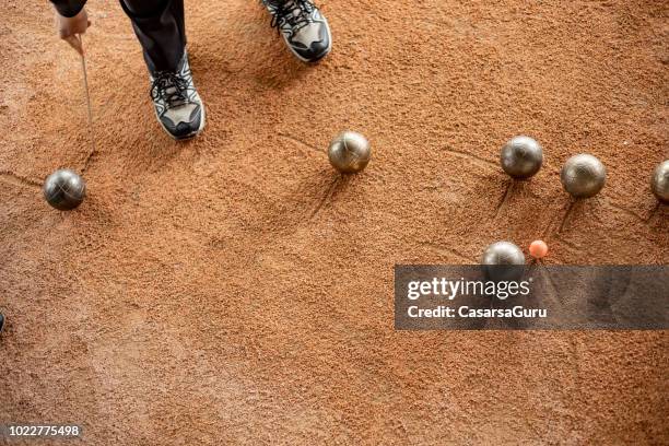 ältere frau markieren, wo die bocciabahn stehen geblieben ist - boules stock-fotos und bilder