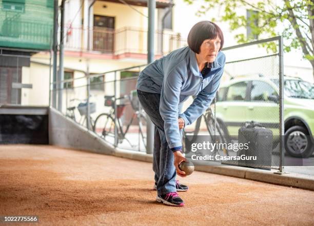 mature woman playing petanque - bocce ball stock pictures, royalty-free photos & images