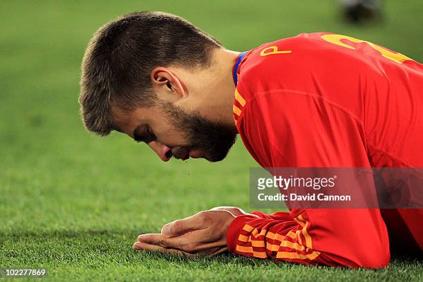 Gerard Pique of Spain lies injured with blood coming from his mouth after he was kicked in the face during the 2010 FIFA World Cup South Africa Group...