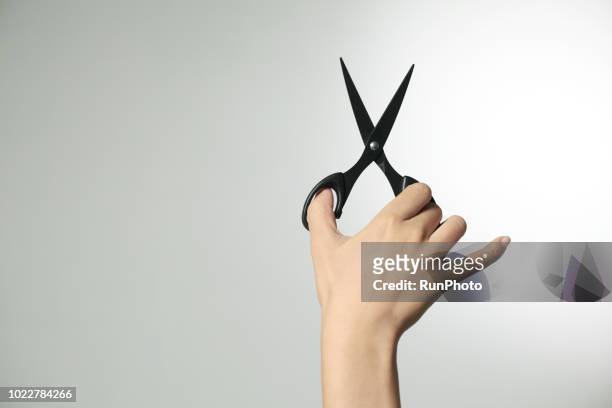hand holding scissors - scissor stock-fotos und bilder