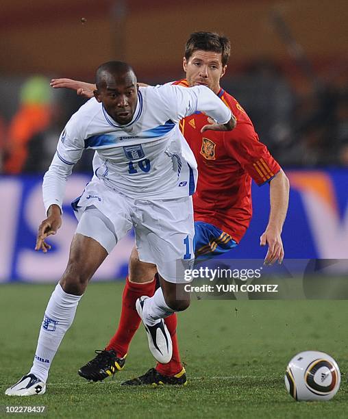 Honduras' midfielder Jerry Palacios is challenged for the ball by Spain's midfielder Xabi Alonso during the 2010 World Cup group H first round...