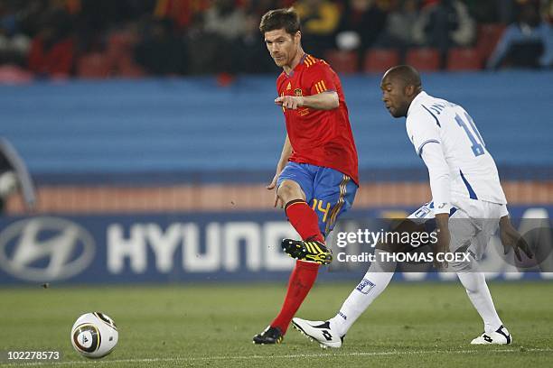 Spain's midfielder Xabi Alonso kicks the ball as Honduras' midfielder Jerry Palacios looks on during the Group H first round 2010 World Cup football...