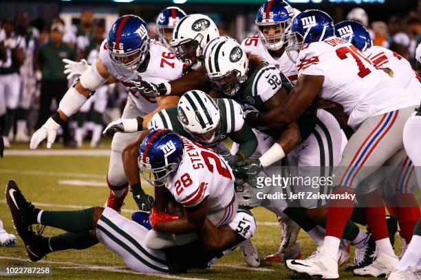 Avery Williamson of the New York Jets takes down Jonathan Stewart of the New York Giants during their preseason game at MetLife Stadium on August 24,...