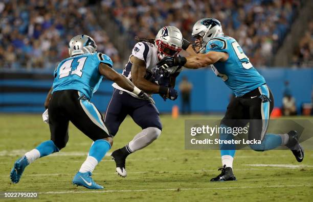 Luke Kuechly and teammate Captain Munnerlyn of the Carolina Panthers tackle Brandon Bolden of the New England Patriots in the second quarter during...