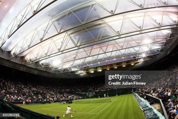 Olivier Rochus of Belgium plays a shot during his first round match against Novak Djokovic of Serbia on Day One of the Wimbledon Lawn Tennis...